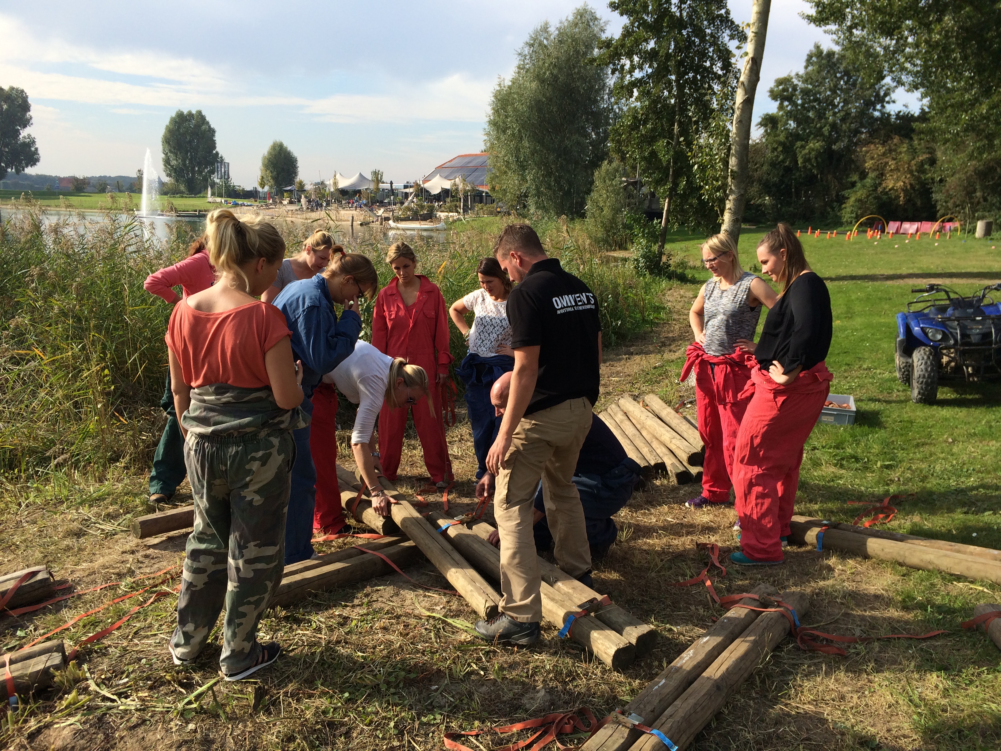 quad teambuilding groep collegas die samen aan het bouwen zijn aan een vlot