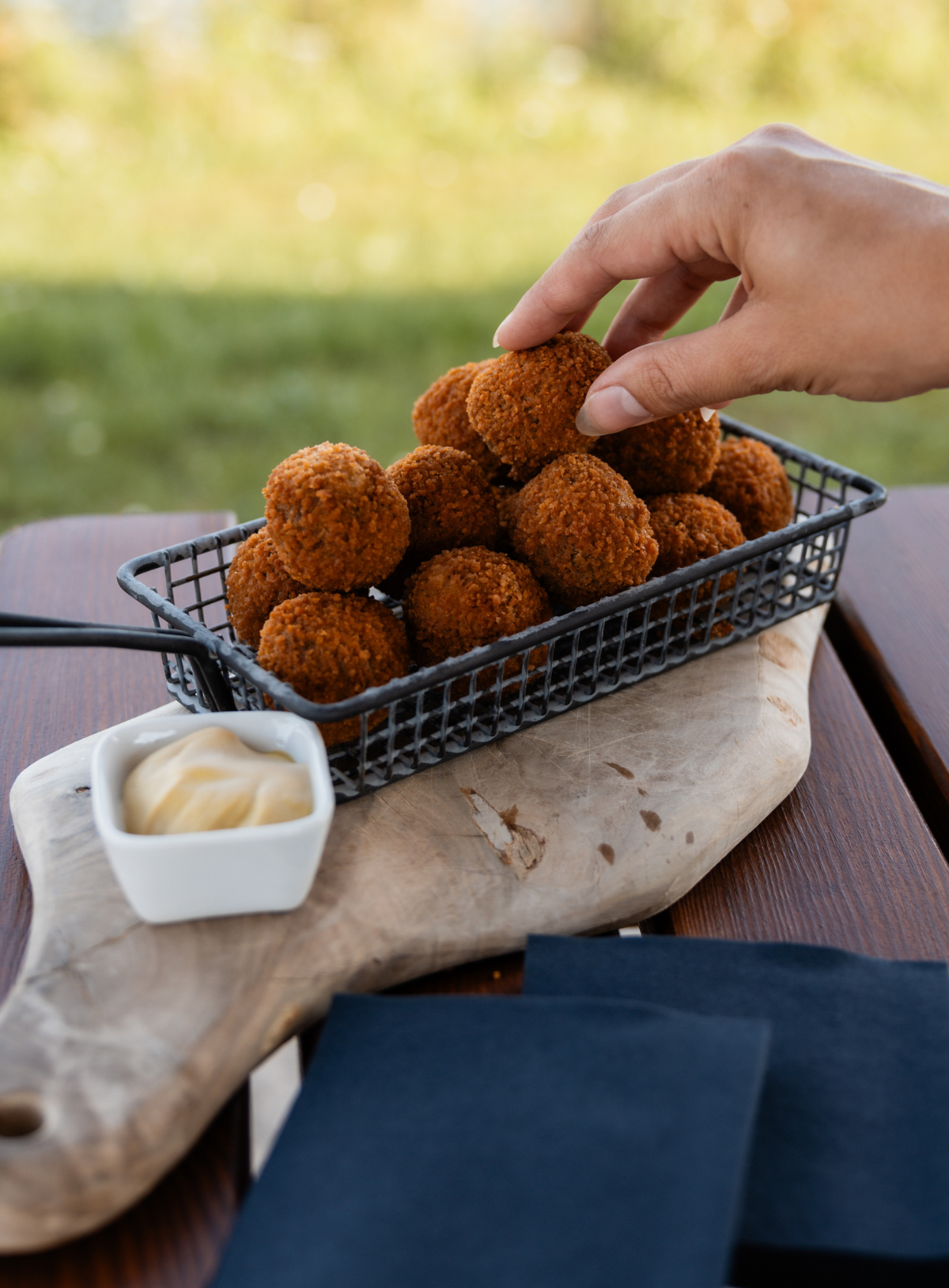 Bitterballen in houder op plankje met mosterd ernaast
