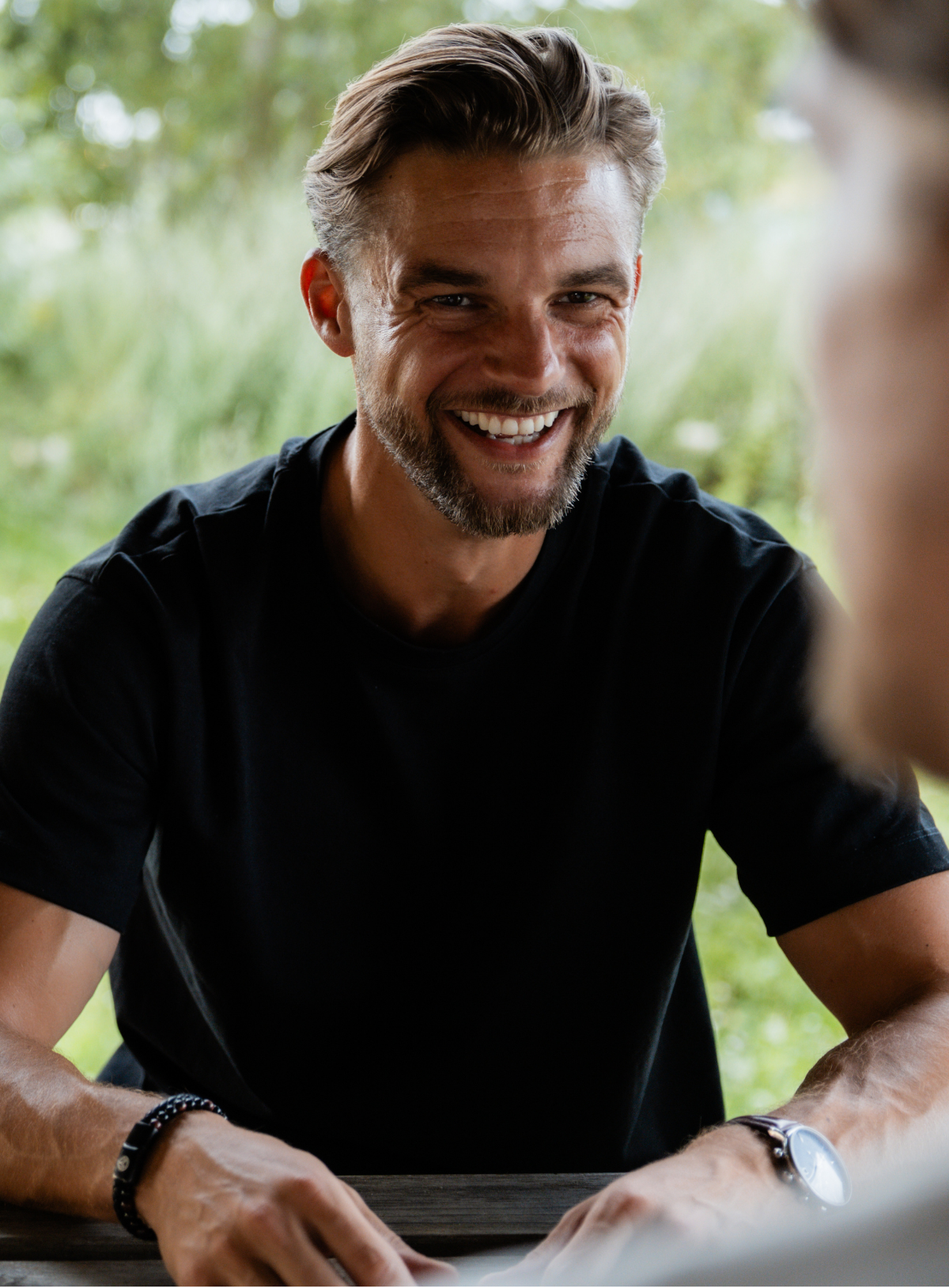 Lachende man aan tafel tijdens potje Shooting Games