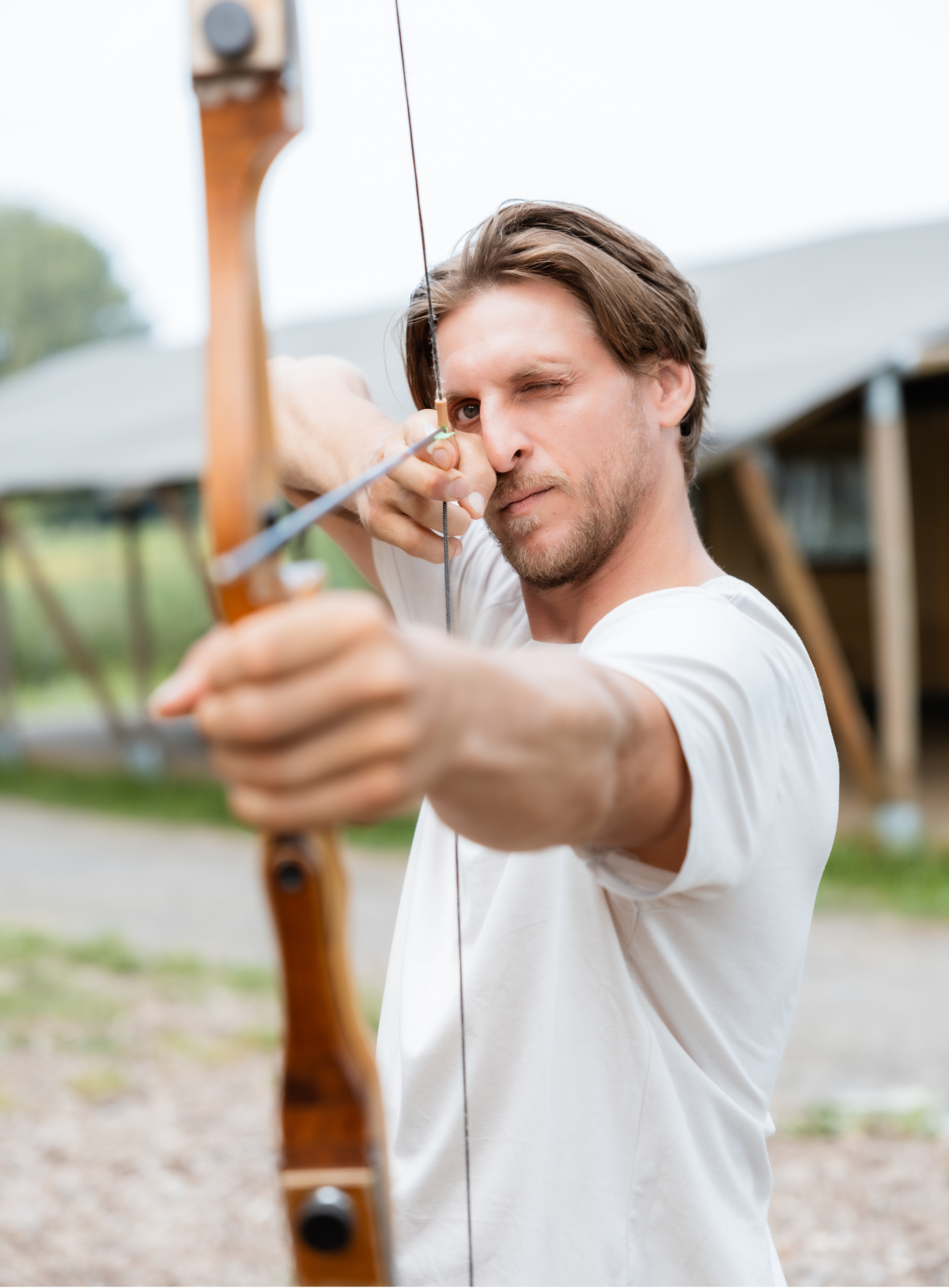 Jongen knijpt zijn oog dicht om te richten op bulls eye