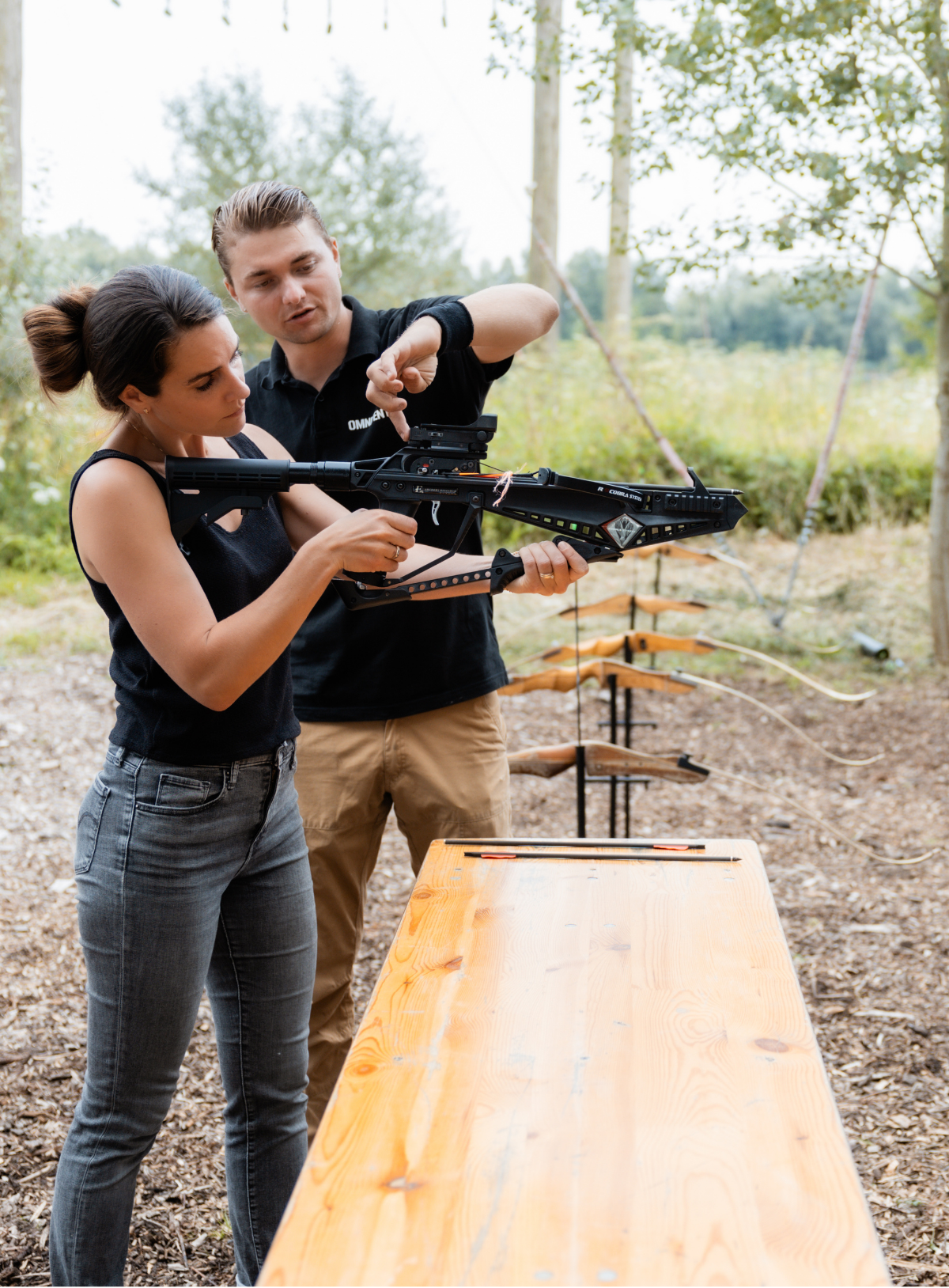 Instructeur geeft instructie aan vrouw die geweer vasthoudt